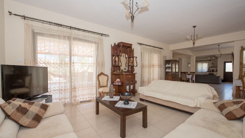The bright open-plan living room with comfortable sofas opening to the dining area