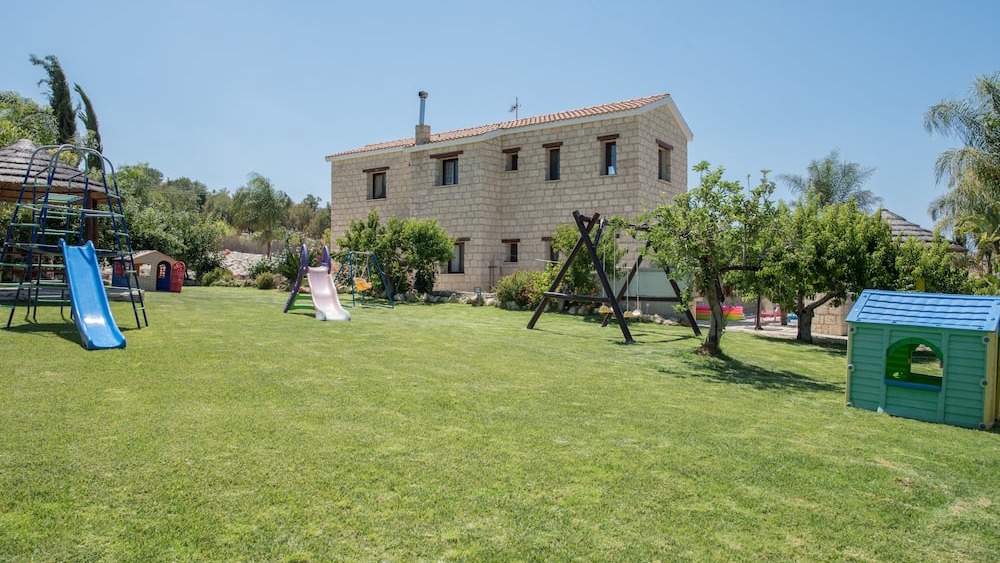 The lawned garden and children's play area beside the house