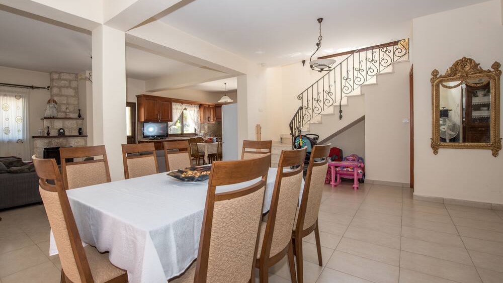 The indoor dining table with the staircase and kitchen beyond