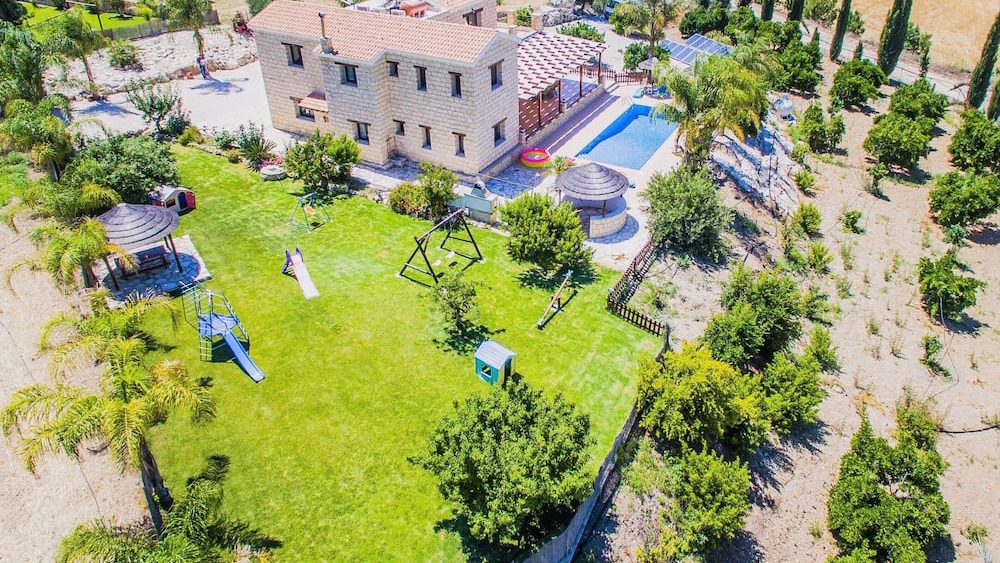 Aerial of the lawned garden and play area beside the villa